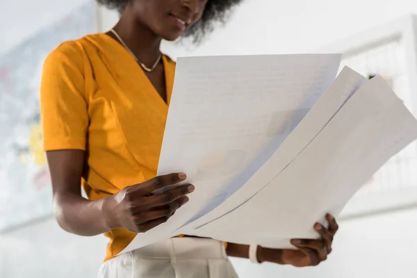 Cropped shot of beautiful african american freelancer with papers in hands at home office — Stock Photo