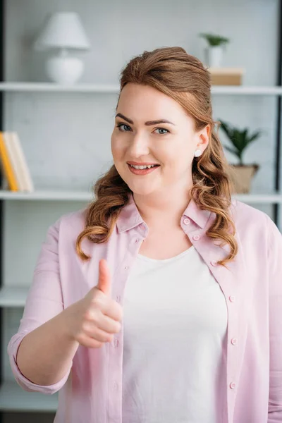 Belle femme montrant pouce à la maison — Photo de stock