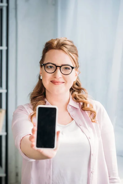 Beautiful woman showing smartphone at home — Stock Photo