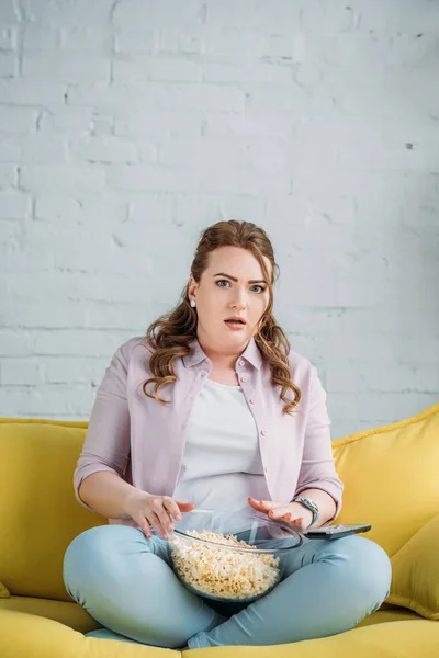 Surpris belle femme regarder film avec pop-corn à la maison — Photo de stock