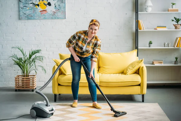 Bella donna pulizia tappeto con aspirapolvere a casa — Foto stock