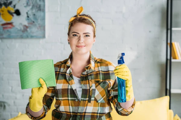 Bella donna che tiene straccio e bottiglia spray per la pulizia a casa — Foto stock