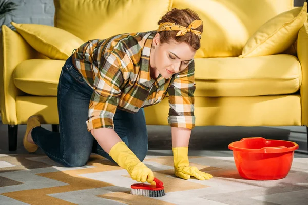 Schöne Frau putzt Teppich zu Hause — Stockfoto