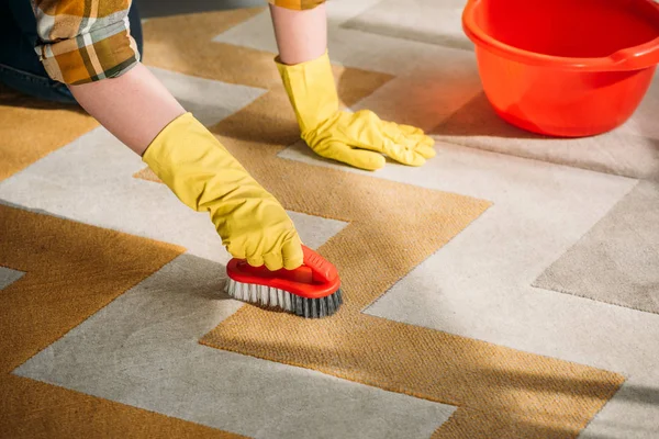 Image recadrée de femme nettoyage tapis à la maison — Photo de stock