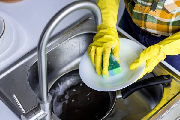 Imagem cortada de mulher placa de lavagem com esponja de lavagem na cozinha — Fotografia de Stock