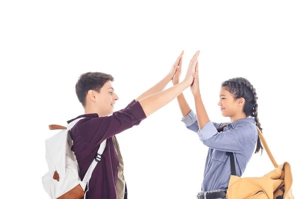 Side view of teenagers with backpacks giving high five to each other isolated on white — Stock Photo