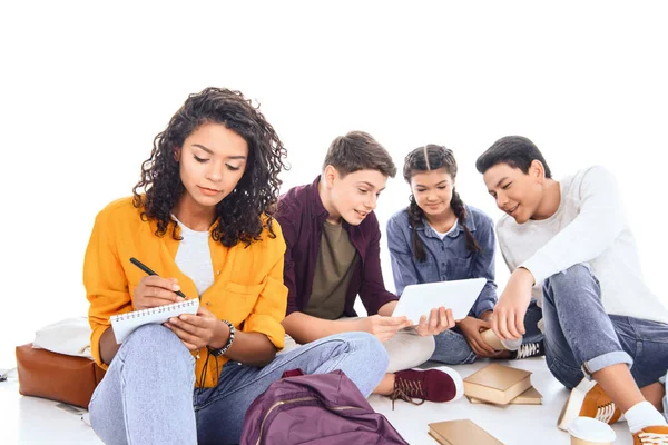 Estudiantes multirraciales con mochilas y cuadernos aislados en blanco - foto de stock