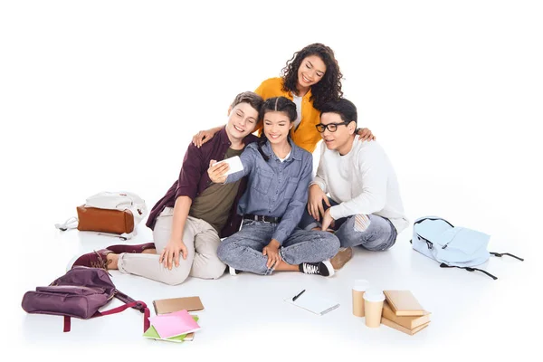 Estudiantes multiculturales tomando selfie juntos aislados en blanco - foto de stock