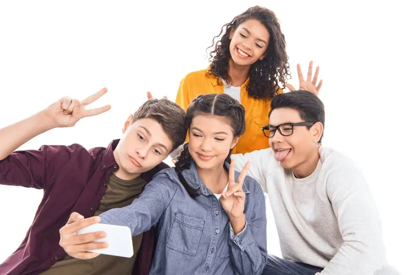 Portrait of multicultural students taking selfie on smartphone together isolated on white — Stock Photo