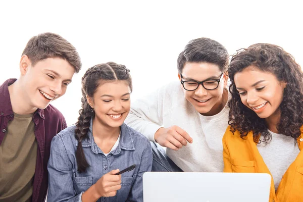 Retrato de amigos adolescentes multiétnicos sonrientes usando el ordenador portátil juntos aislados en blanco - foto de stock