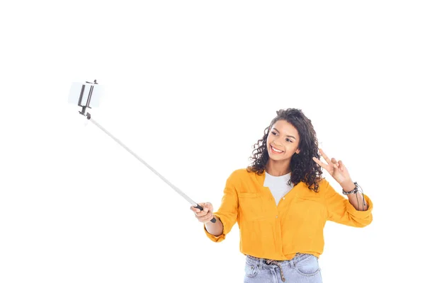 Portrait of smiling african american teenager taking selfie on smartphone isolated on white — Stock Photo