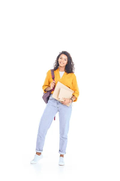 Estudiante afroamericano sonriente con mochila y libros aislados en blanco — Stock Photo