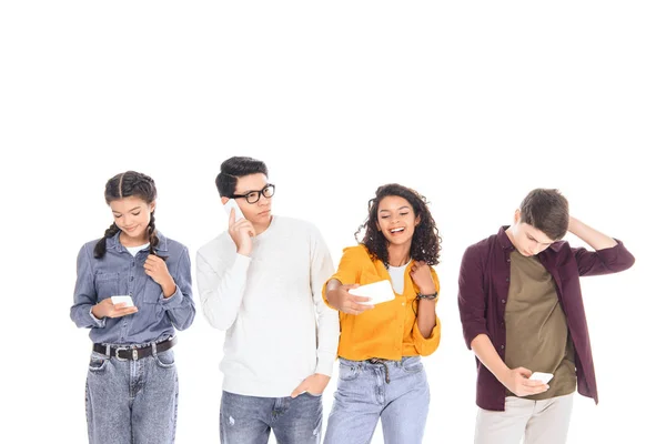 Portrait of multicultural teen friends with smartphones isolated on white — Stock Photo