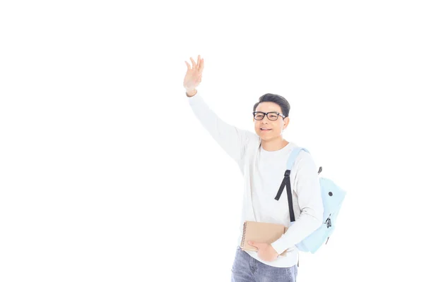 Retrato de estudiante asiático con mochila y cuadernos saludando a alguien aislado en blanco - foto de stock