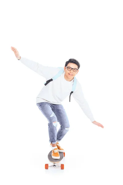 Asiatique adolescent avec sac à dos équitation skateboard isolé sur blanc — Photo de stock