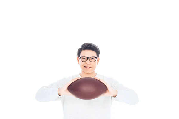 Retrato de sorrindo asiático adolescente em óculos com bola de rugby em mãos isoladas no branco — Fotografia de Stock