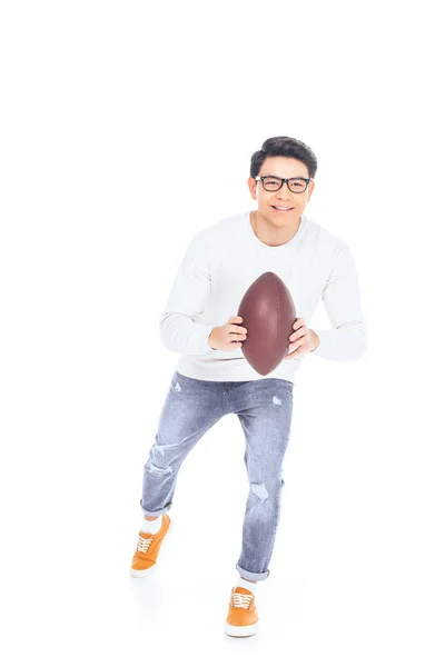 Smiling asian teenager in eyeglasses with rugby ball in hands isolated on white — Stock Photo