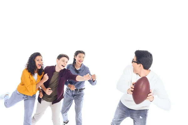 Interracial teen friends playing with rugby ball isolated on white — Stock Photo