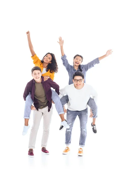 Glücklich interracial teen friends huckepack zusammen isoliert auf weiß — Stockfoto