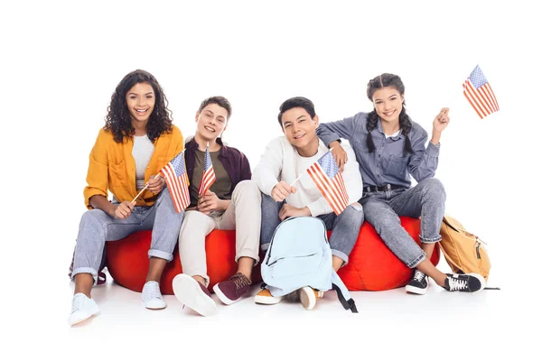 Group of teen students with usa flags sitting on bean bags isolated on white — Stock Photo