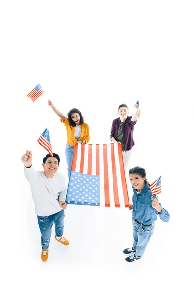 Vista de ángulo alto del grupo de adolescentes multiétnicos con banderas de EE.UU. aisladas en blanco - foto de stock