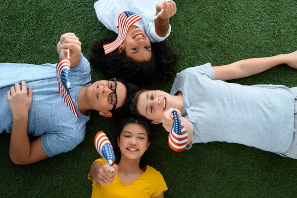 Vue du dessus du groupe d'étudiants adolescents avec des drapeaux américains sur l'herbe verte — Photo de stock