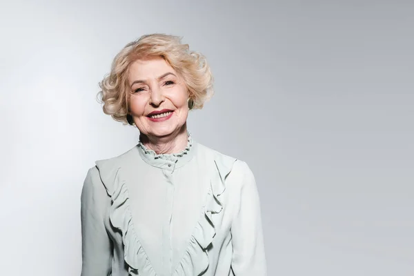 Portrait en gros plan de heureuse femme âgée en chemise élégante isolée sur gris — Photo de stock