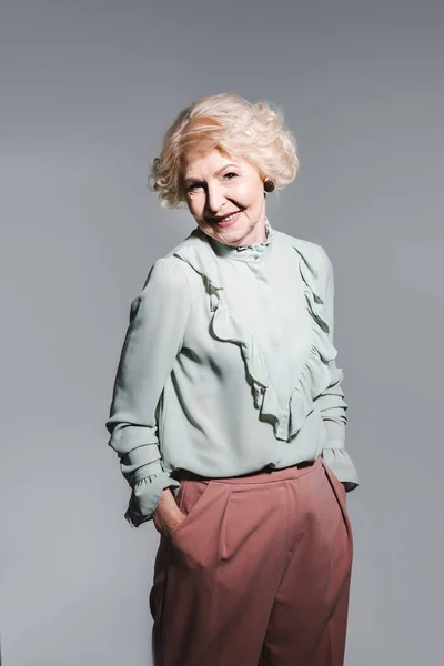 Retrato de cerca de una hermosa mujer mayor aislada en gris - foto de stock