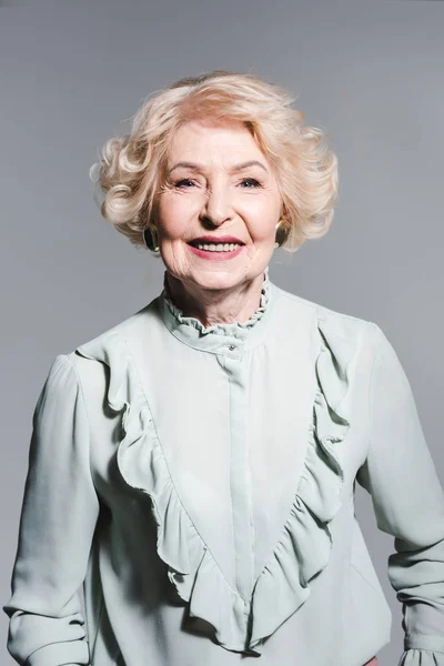 Portrait en gros plan d'une femme âgée souriante isolée sur fond gris — Photo de stock