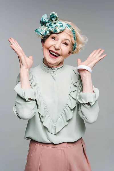 Здивована старша жінка в стильному одязі ізольована на сірому — стокове фото