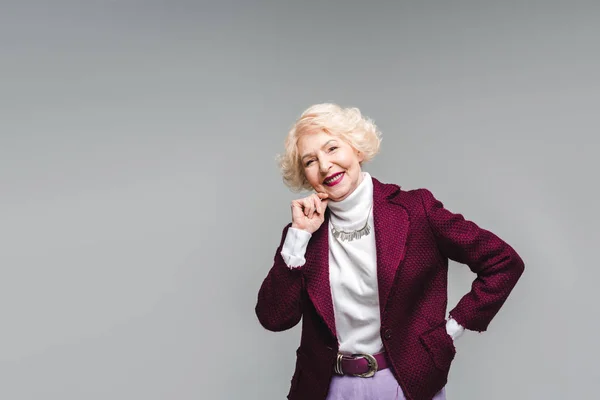 Glückliche Seniorin in stylischem Sakko und Rollkragen isoliert auf grau — Stockfoto