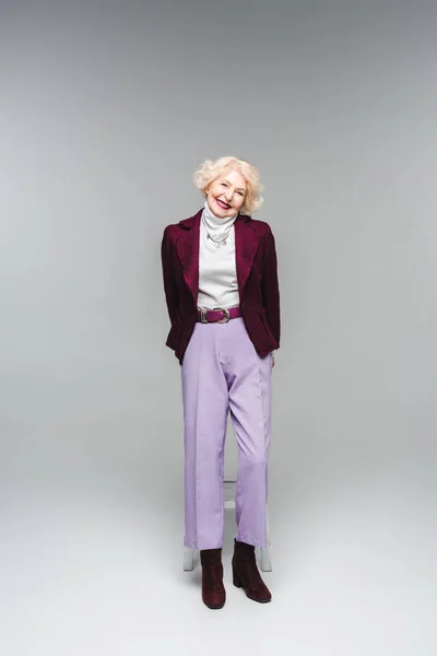 Hermosa mujer mayor en ropa vintage con estilo en gris - foto de stock