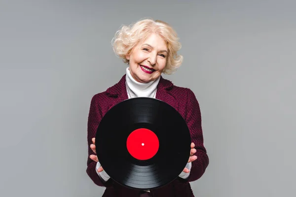 Stilvolle Seniorin hält Vinyl-Disc isoliert auf grauem Hintergrund — Stock Photo