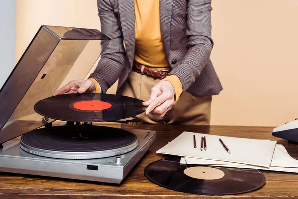 Cropped shot of woman turning on vinyl record player — Stock Photo