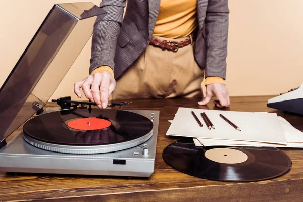 Cropped image of woman turning on vinyl record player — Stock Photo