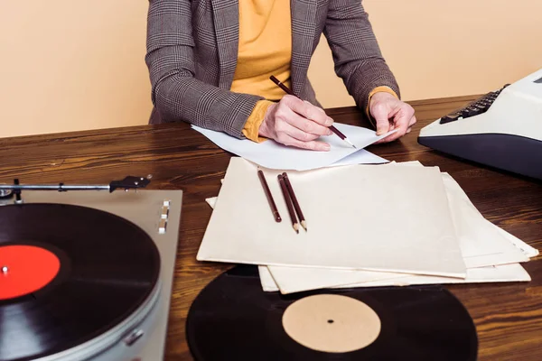 Imagem recortada de mulher escrevendo em papel à mesa com disco de vinil, gravador e máquina de escrever — Fotografia de Stock