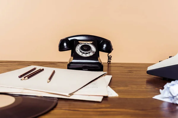 Крупним планом знімок ротаційного телефону на дерев'яному столі з друкарською машинкою і вініловим диском на столі — стокове фото