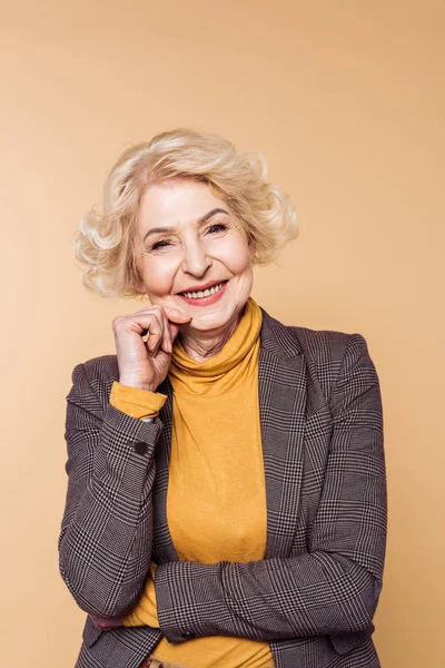 Donna anziana alla moda posa isolata su sfondo beige — Foto stock