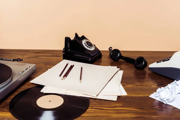 Ротаційний телефон, вініловий диск, програвач запису та друкарська машинка на дерев'яному столі — стокове фото