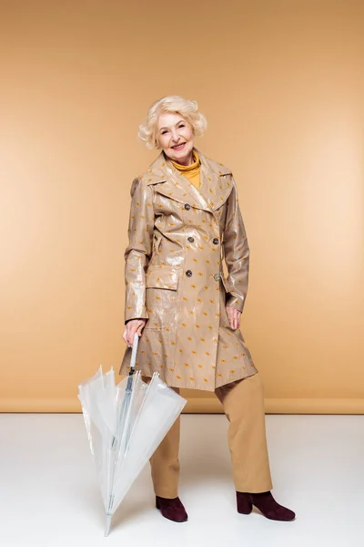 Donna anziana alla moda in trench con ombrello — Foto stock