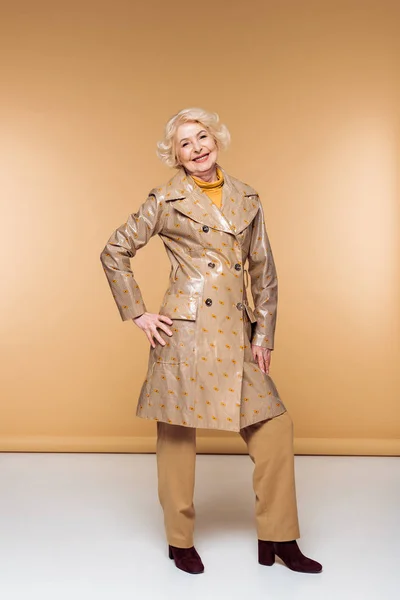 Happy stylish senior woman posing in trench coat — Stock Photo