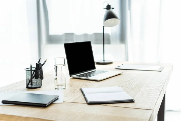 Lugar de trabajo con ordenador portátil y diferentes suministros en la oficina moderna - foto de stock