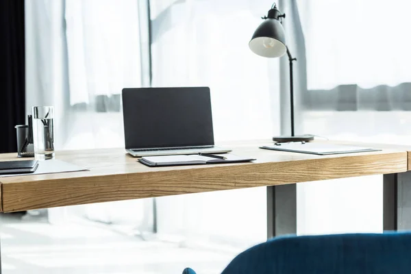 Lugar de trabajo con ordenador portátil y varios suministros en la oficina moderna - foto de stock