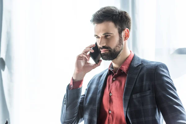 Joven hombre de negocios guapo en traje elegante hablando por teléfono - foto de stock