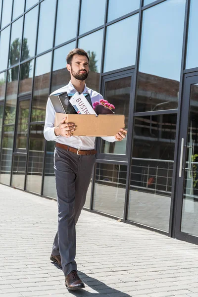 Young manager with box of personal stuff outdoors after he was fired — Stock Photo