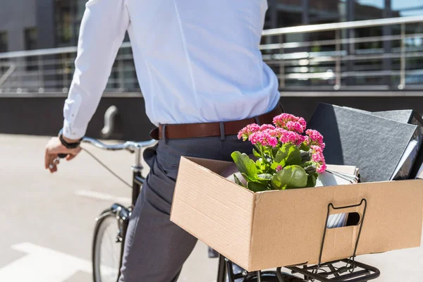 Schnappschuss von Manager auf Fahrrad mit Kiste voller persönlicher Sachen im Kofferraum — Stockfoto