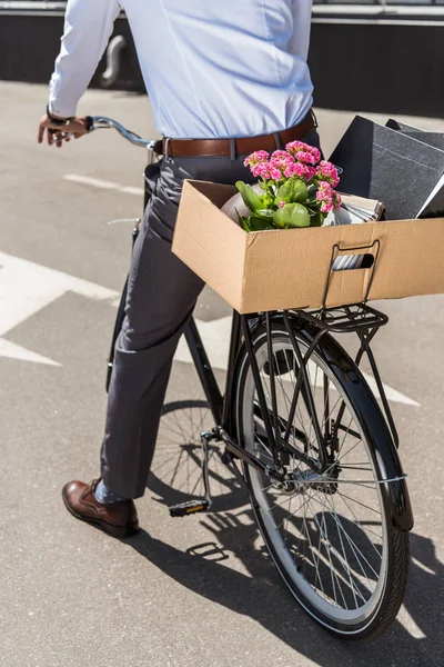 Cropped shot of manager riding on bicycle with box on trunk — Stock Photo