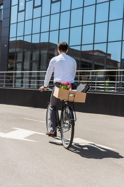 Rückansicht des Managers auf Fahrrad mit Kiste im Kofferraum — Stockfoto