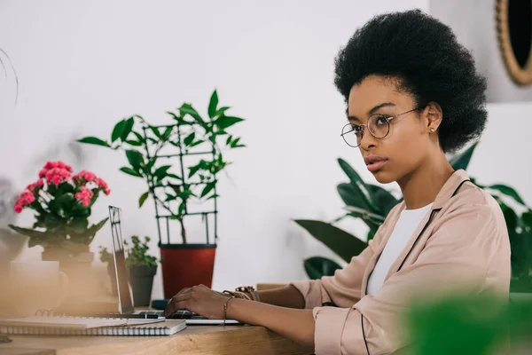 Attraktive afrikanisch-amerikanische Geschäftsfrau mit Laptop im Büro — Stockfoto