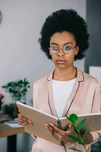 Attraente donna d'affari africana americana in possesso di notebook in ufficio — Foto stock